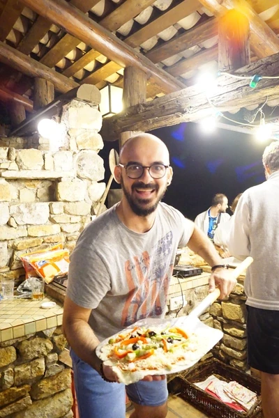 Greg montrant sa Pizza